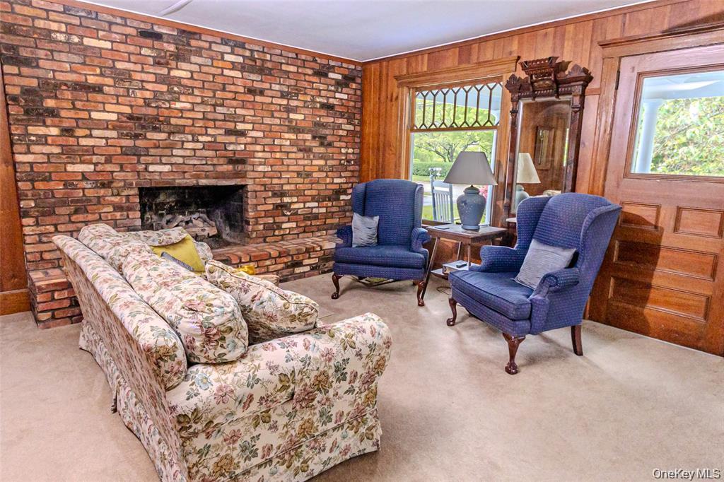 630 New Suffolk Road Cutchogue, NY 11935 - Photo 9 of 33 a living room with furniture a fireplace and a floor to ceiling window