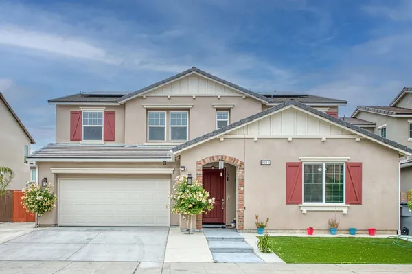 a front view of a house with a garden and garage