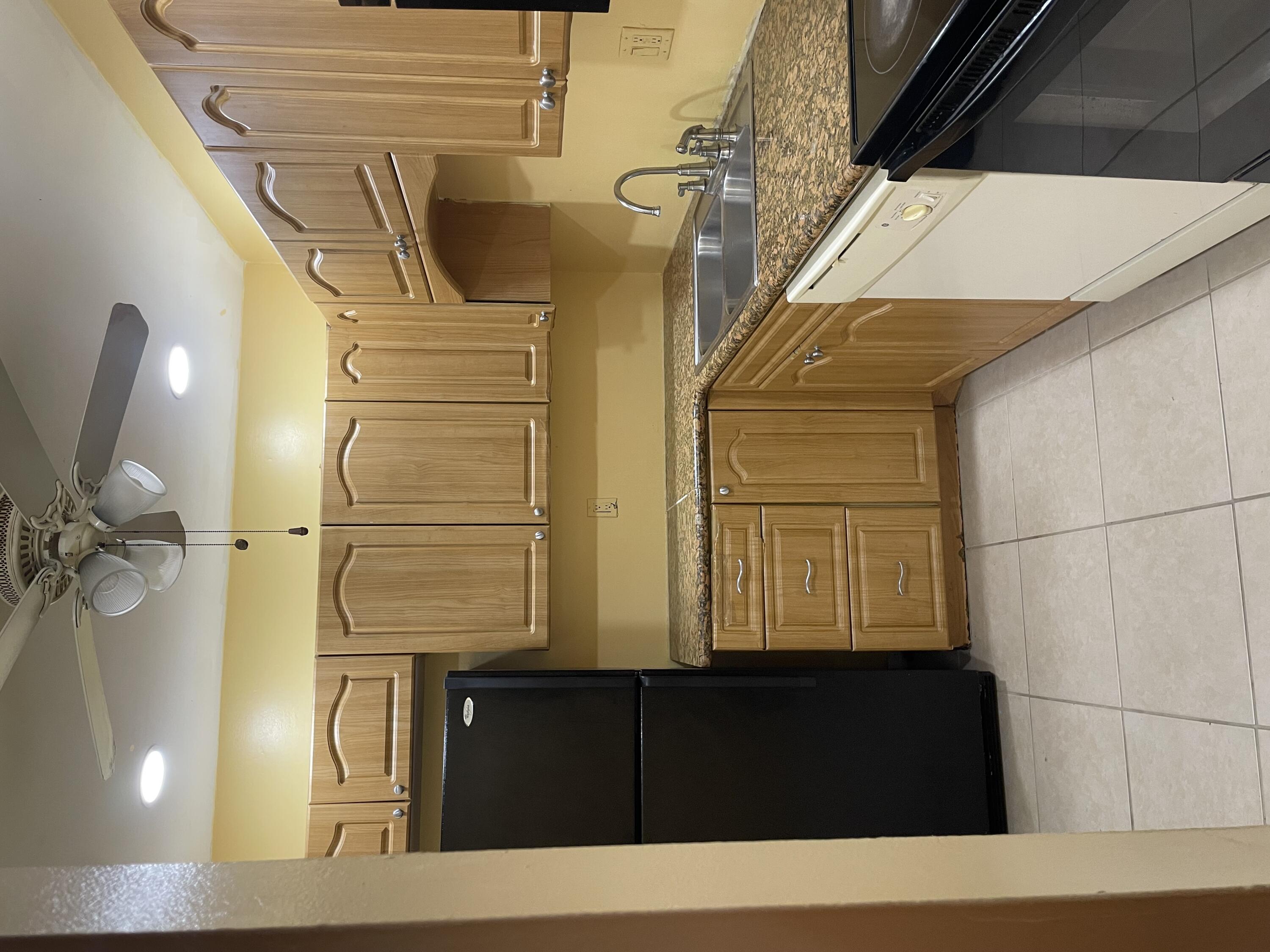 632 Northwest 13th Street, Unit 12 Boca Raton, FL 33486 - Photo 1 of 12 a kitchen with a refrigerator and a sink