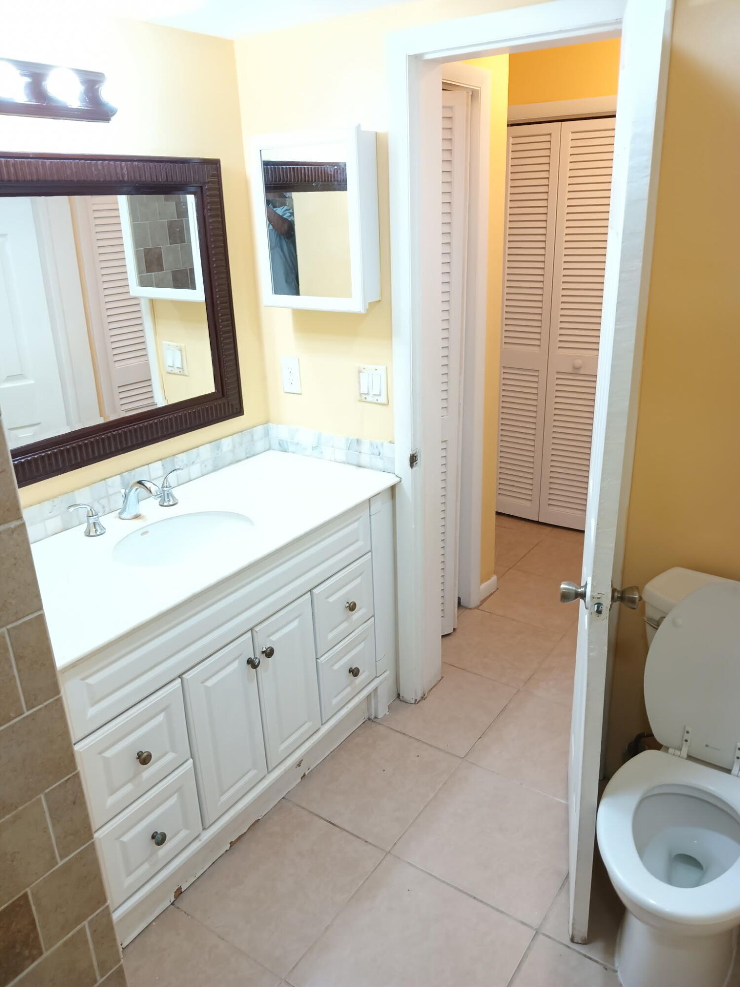 632 Northwest 13th Street, Unit 12 Boca Raton, FL 33486 - Photo 8 of 12 a bathroom with a toilet sink and mirror