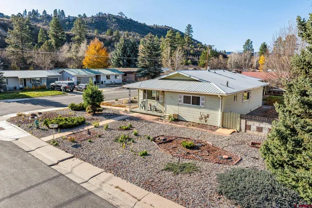 a view of a house with a big yard and large trees