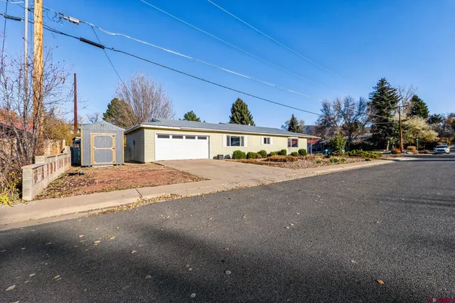 a view of a white house with a yard and plants