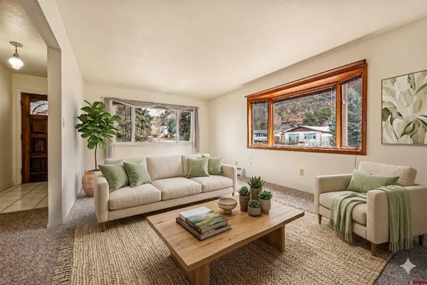 a view of a dining room with furniture and a kitchen view