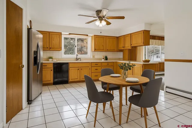 a kitchen with stainless steel appliances granite countertop a sink a stove a dining table and chairs