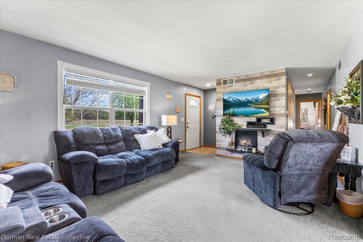 Carpeted living area with a large fireplace 