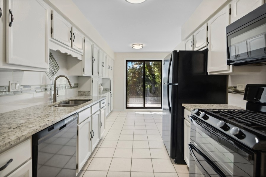 1-s150 Spring Road, Unit 4D Oak Brook, IL 60181 - Photo 7 of 13 a kitchen with stainless steel appliances granite countertop a sink stove and refrigerator