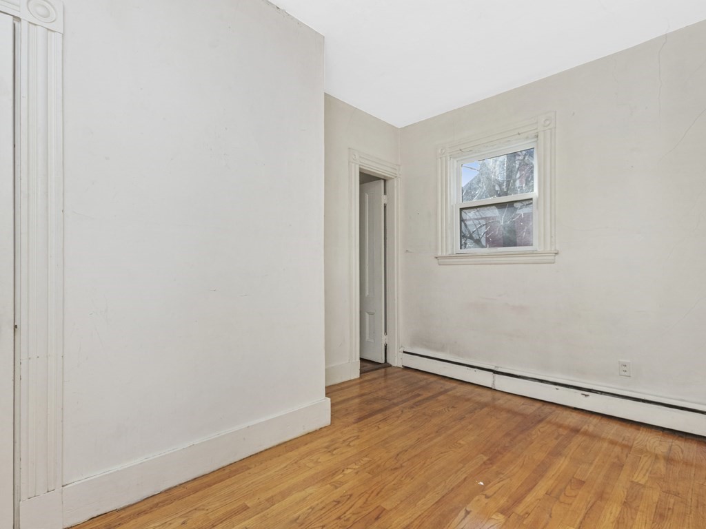 90 Addington Road, Unit 2 Brookline, MA 02445 - Photo 16 of 41 an empty room with wooden floor and windows