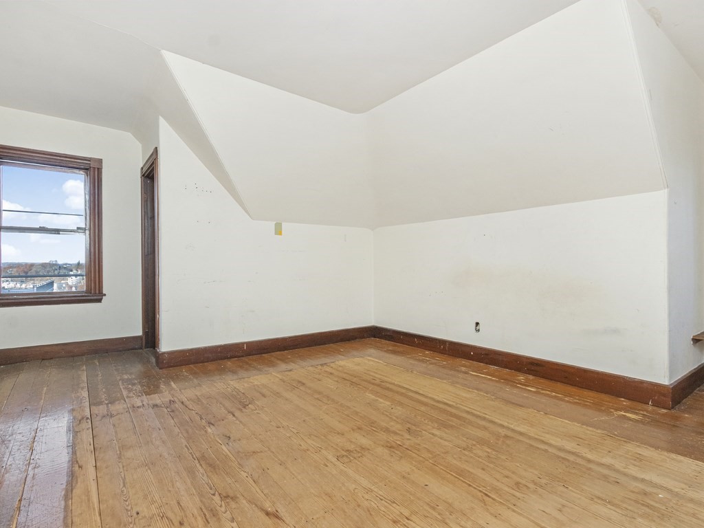 90 Addington Road, Unit 2 Brookline, MA 02445 - Photo 23 of 41 a view of an empty room with wooden floor and a window
