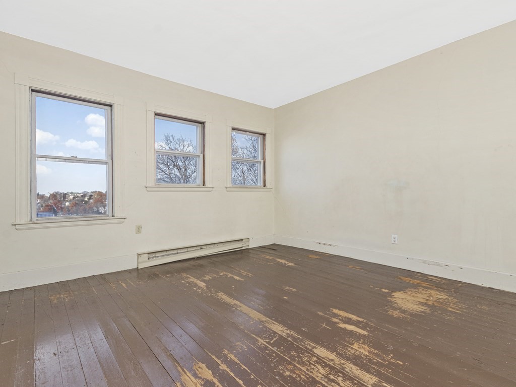90 Addington Road, Unit 2 Brookline, MA 02445 - Photo 25 of 41 an empty room with wooden floor and window