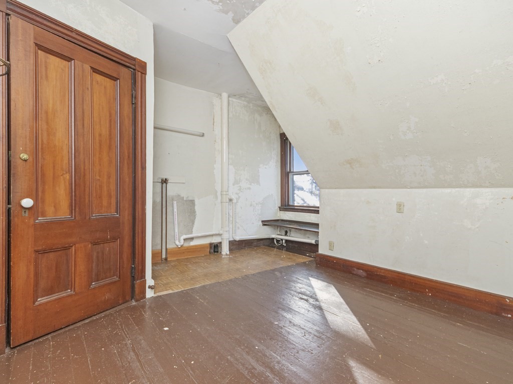 90 Addington Road, Unit 2 Brookline, MA 02445 - Photo 28 of 41 a view of an empty room with stairs and a window