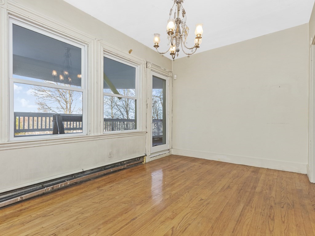 90 Addington Road, Unit 2 Brookline, MA 02445 - Photo 7 of 41 a view of an empty room with wooden floor and a window
