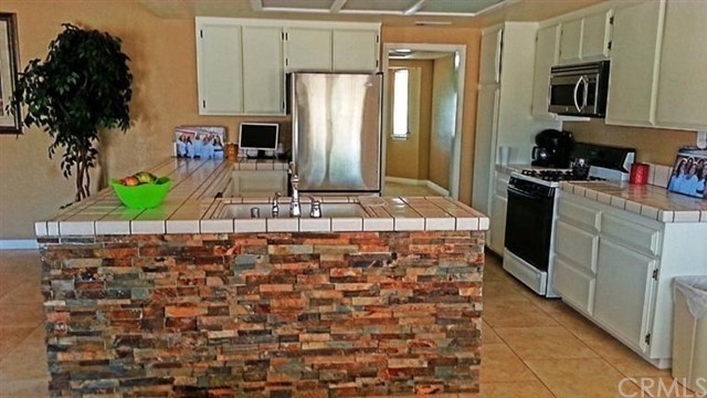 7396 Minstead Avenue Hesperia, CA 92345 - Photo 2 of 3 a kitchen with stainless steel appliances granite countertop a refrigerator and a stove