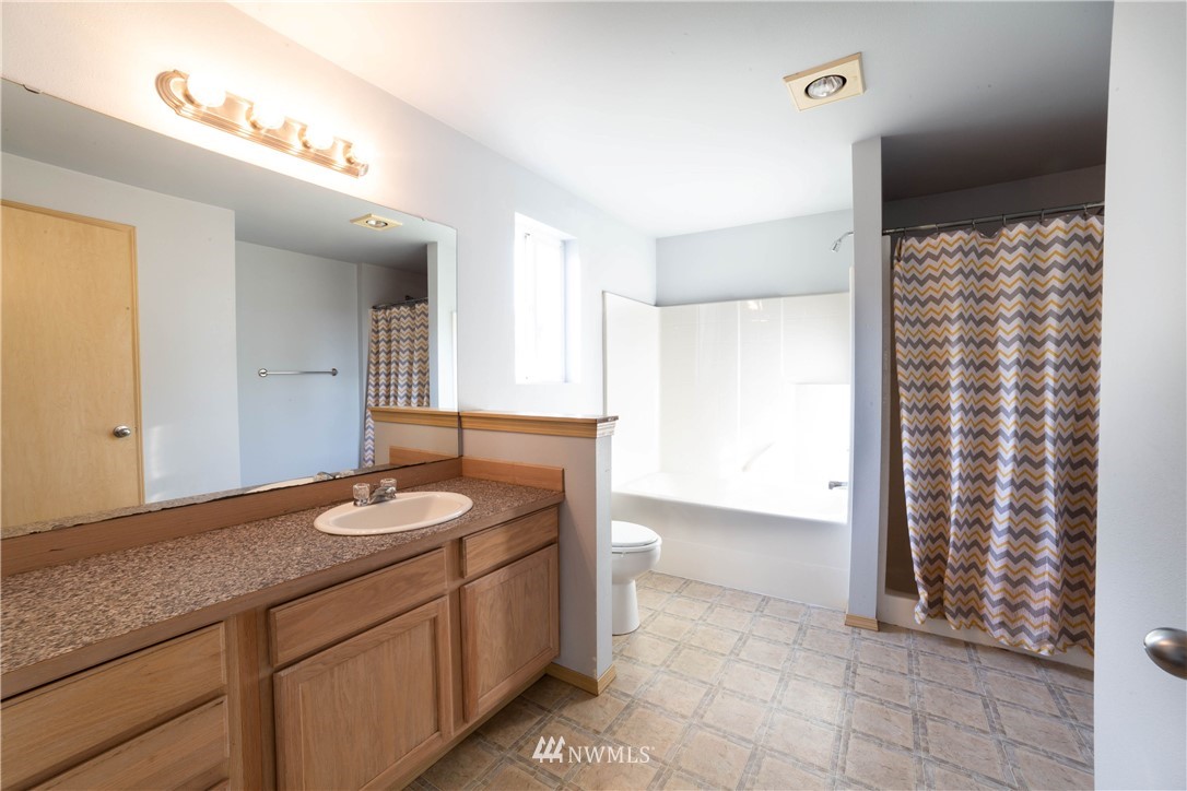 14724 Mima Road Southwest Olympia, WA 98512 - Photo 8 of 14 a spacious bathroom with a granite countertop sink a mirror and shower