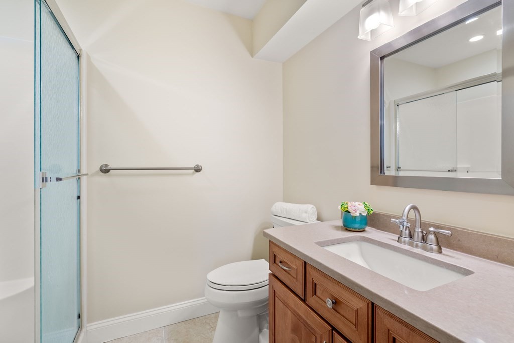 375 Border Street, Unit 375 Boston, MA 02128 - Photo 21 of 34 a bathroom with a granite countertop sink a toilet and a mirror