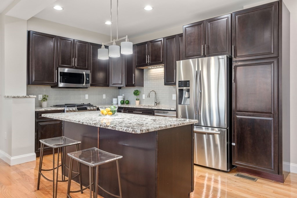 375 Border Street, Unit 375 Boston, MA 02128 - Photo 5 of 34 a kitchen with kitchen island granite countertop stainless steel appliances and refrigerator