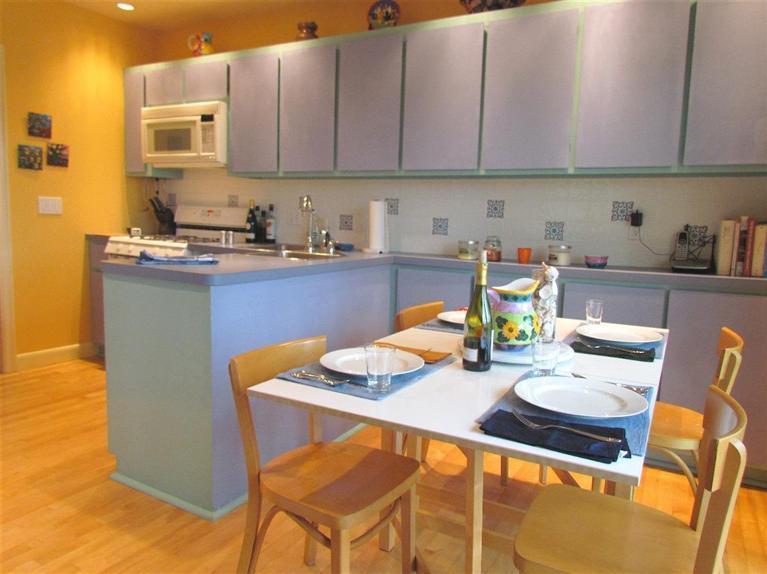100 Fells Pond Road Mashpee, MA 02649 - Photo 7 of 13 a kitchen with stainless steel appliances kitchen island granite countertop a table chairs in it and wooden floor
