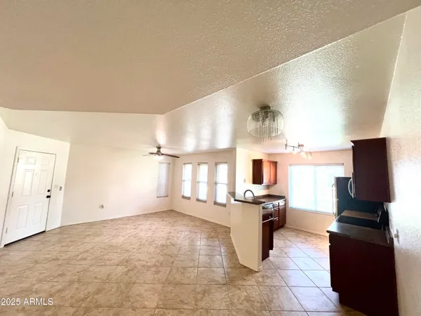 a kitchen with granite countertop a refrigerator stove top oven and cabinets