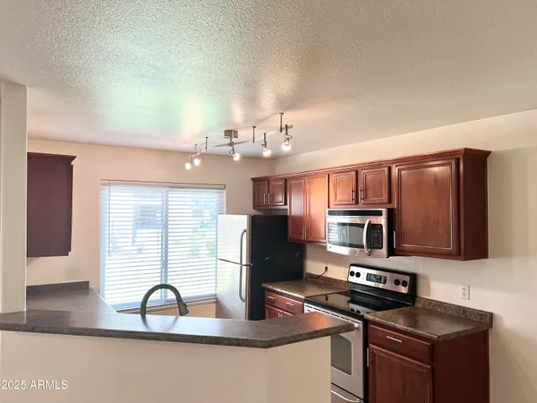 a kitchen with stainless steel appliances a sink a stove and microwave