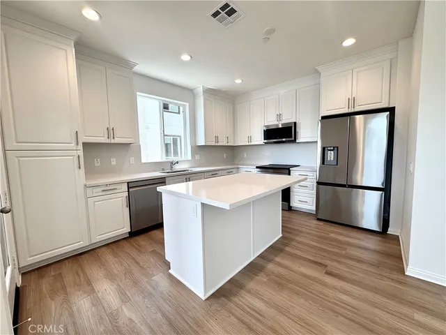 a kitchen with stainless steel appliances granite countertop a white stove top oven and refrigerator
