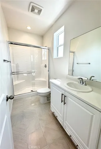 a bathroom with a granite countertop sink mirror vanity and toilet