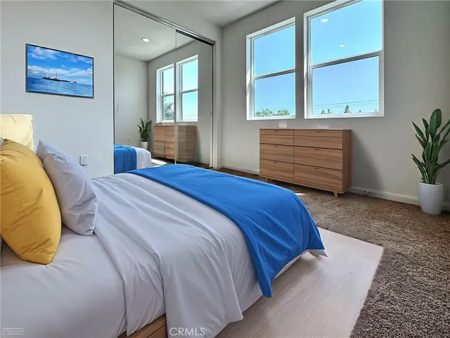 a bedroom with a bed and a potted plant