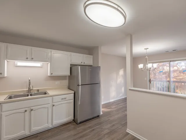 a kitchen with white cabinets and white appliances