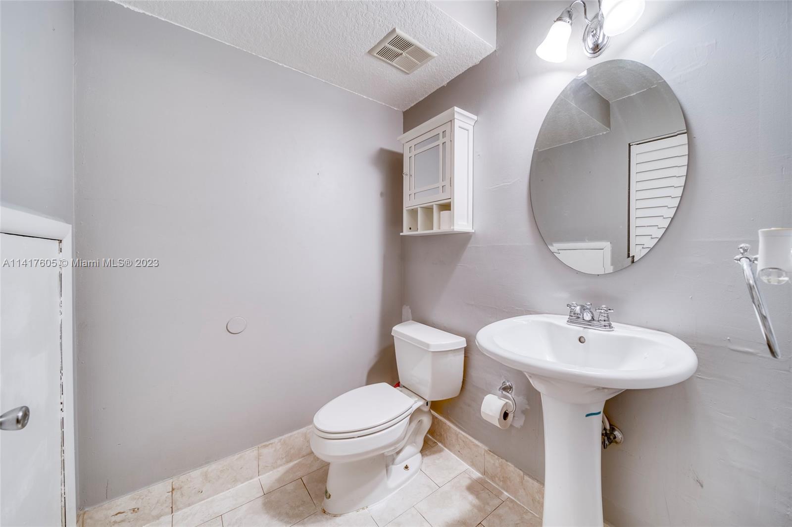13440 Southwest 62nd Street, Unit G101 Miami, FL 33183 - Photo 16 of 25 a bathroom with a toilet sink and mirror
