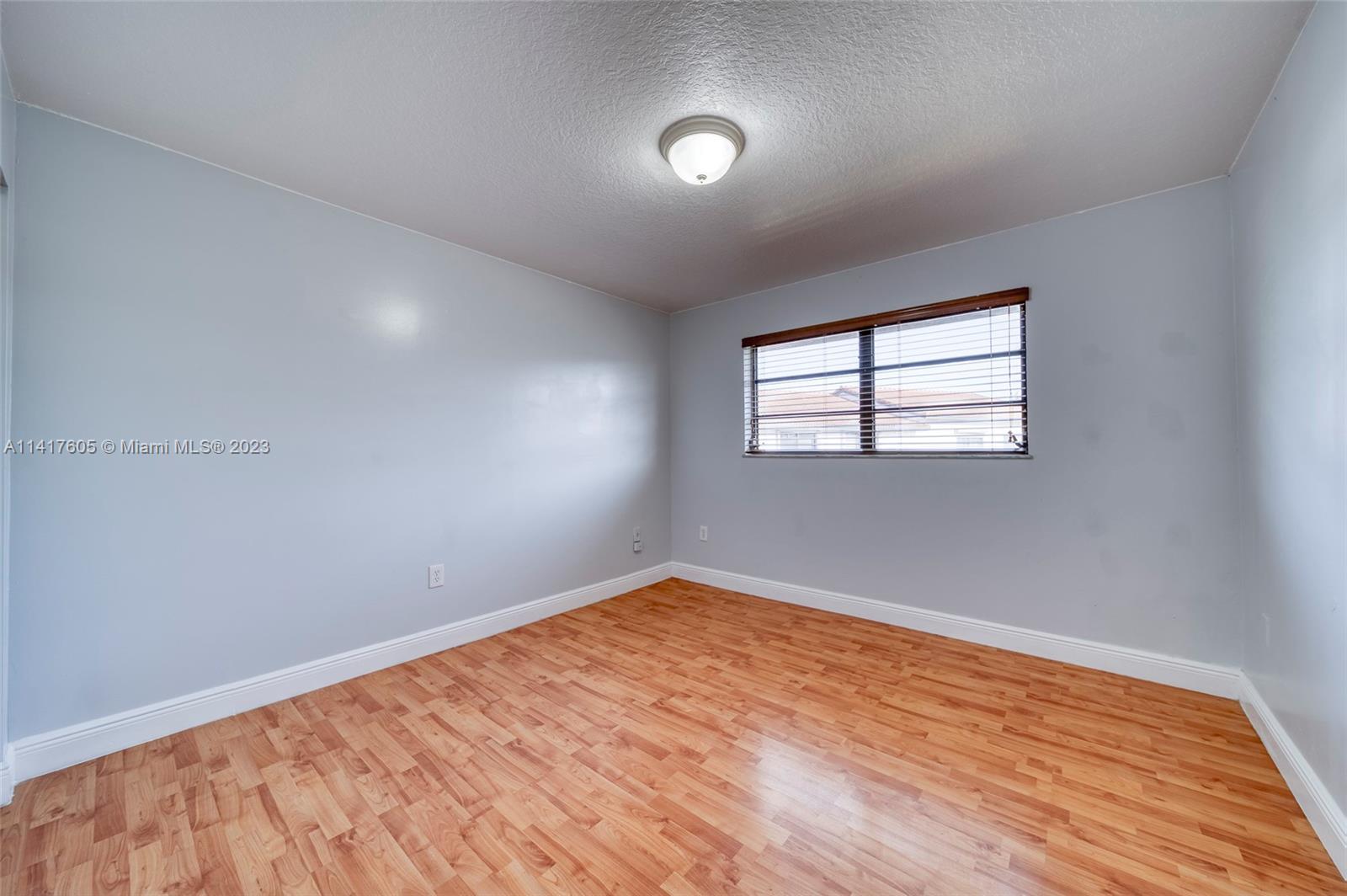 13440 Southwest 62nd Street, Unit G101 Miami, FL 33183 - Photo 21 of 25 an empty room with wooden floor and windows