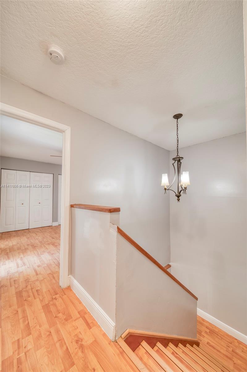 13440 Southwest 62nd Street, Unit G101 Miami, FL 33183 - Photo 23 of 25 a view of a room with wooden floor and ceiling fan