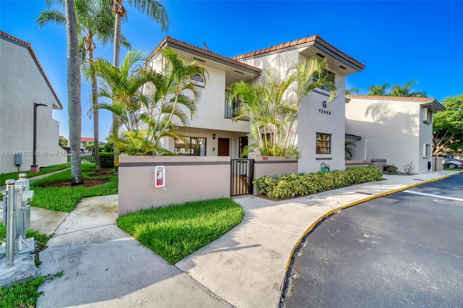 13440 Southwest 62nd Street, Unit G101 Miami, FL 33183 - Photo 3 of 25 a front view of a house with a yard and garage