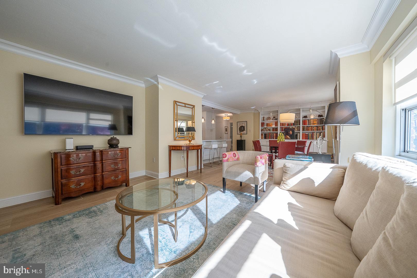 118 South 21st Street, Unit 31112 Philadelphia, PA 19103 - Photo 1 of 26 a living room with furniture a lamp and a large window