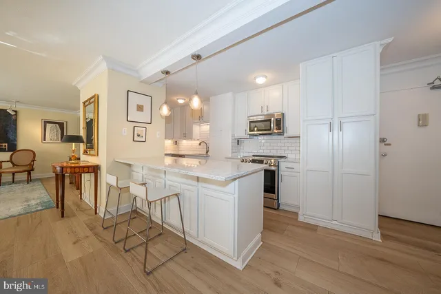 a kitchen with white cabinets and stainless steel appliances