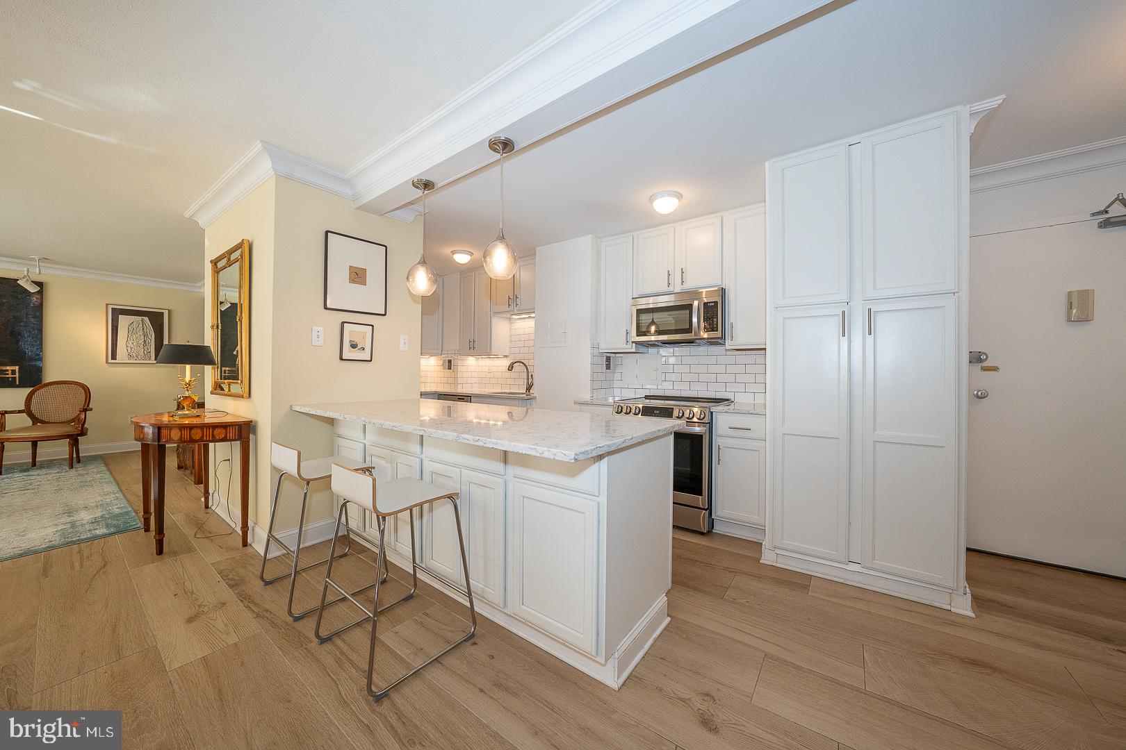118 South 21st Street, Unit 31112 Philadelphia, PA 19103 - Photo 5 of 26 a kitchen with white cabinets and stainless steel appliances
