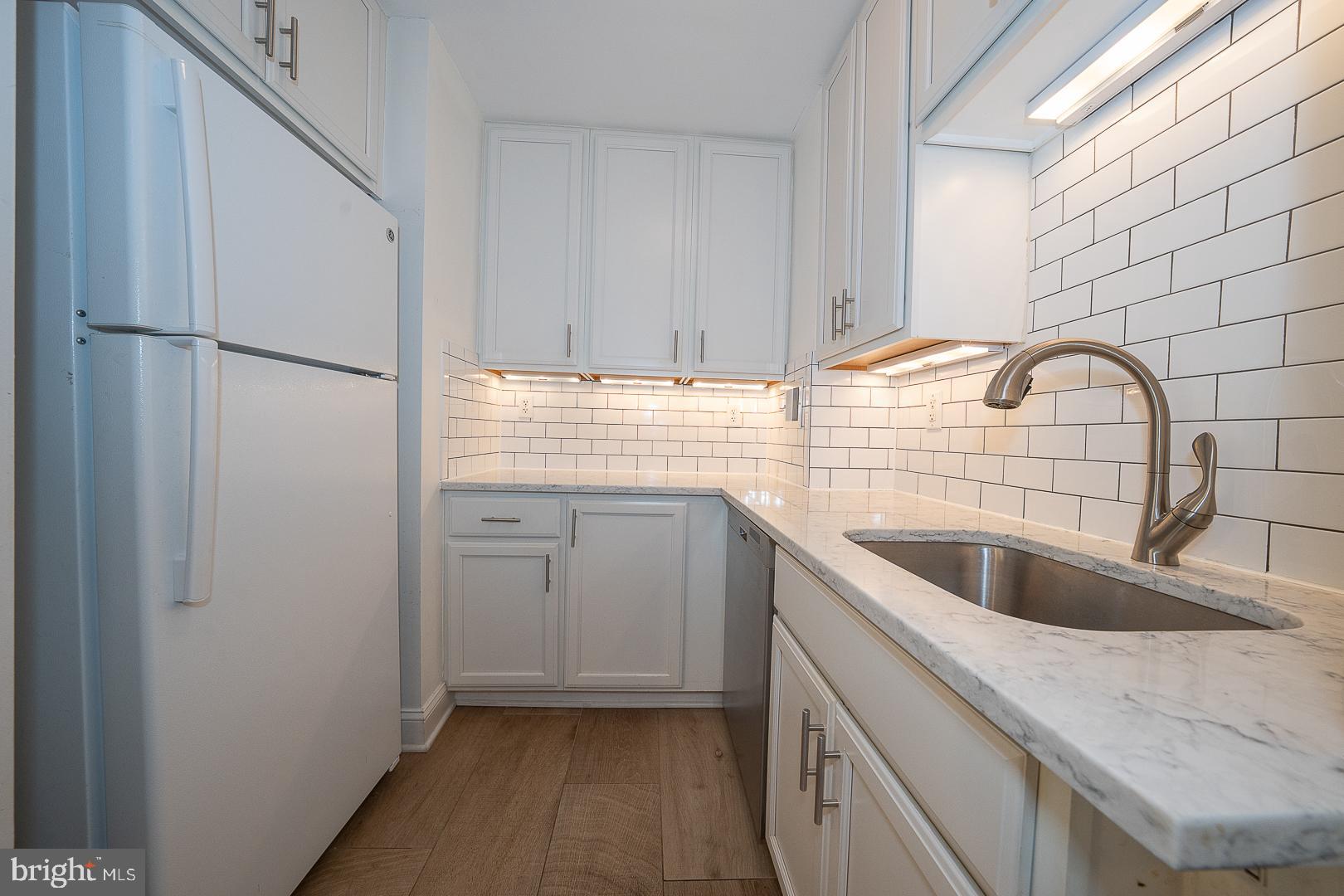 118 South 21st Street, Unit 31112 Philadelphia, PA 19103 - Photo 7 of 26 a kitchen with a sink cabinets and washer
