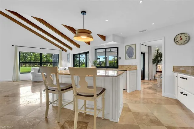a view of a dining room and livingroom with furniture wooden floor a chandelier