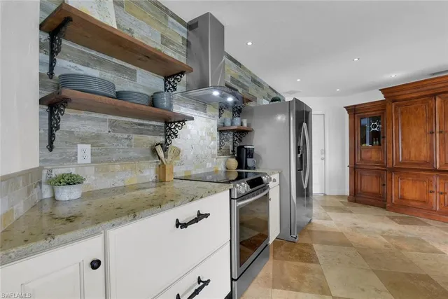 a kitchen with stainless steel appliances granite countertop a sink a stove and a refrigerator