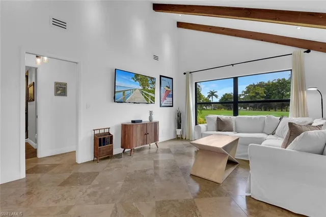 a living room with furniture a rug and a large window