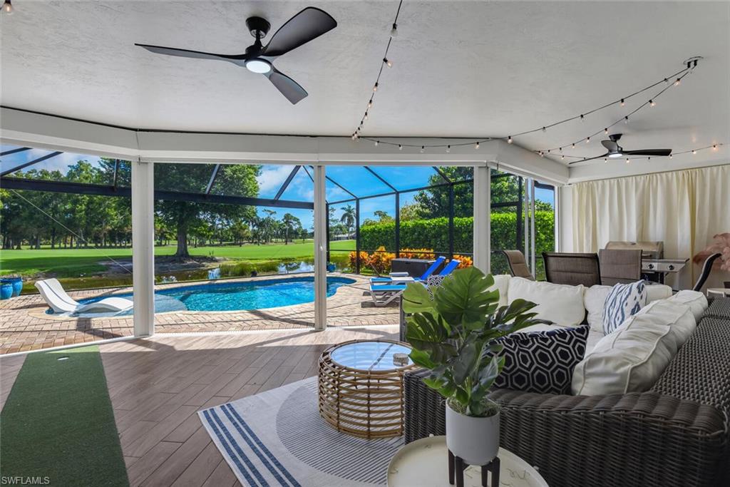 167 Torrey Pines Point Naples, FL 34113 - Photo 28 of 37 a living room with patio furniture and a floor to ceiling window