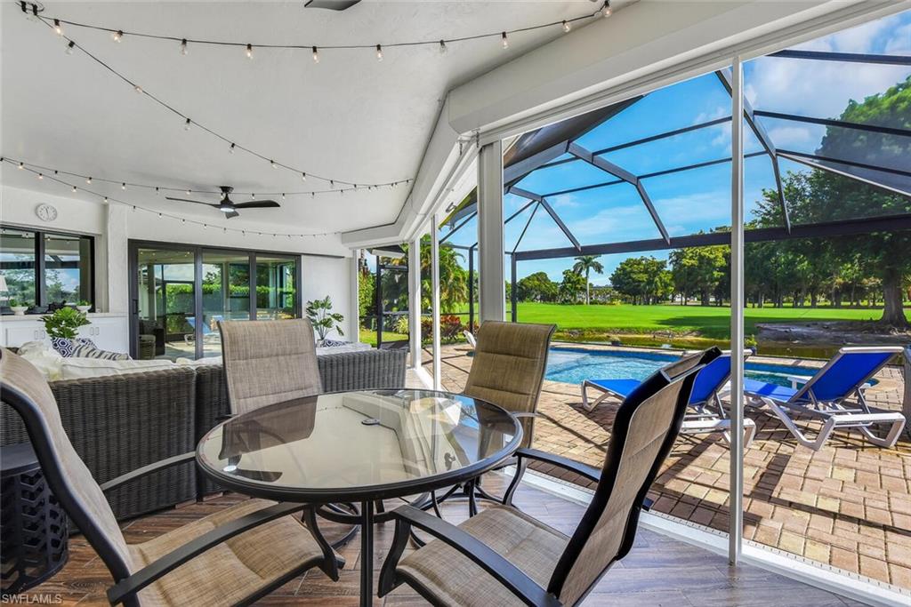 167 Torrey Pines Point Naples, FL 34113 - Photo 30 of 37 a view of a patio with table and chairs potted plants with wooden floor