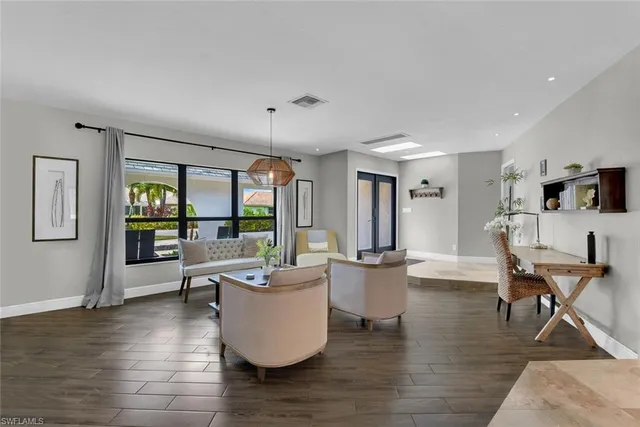 a living room with furniture wooden floor and a large window