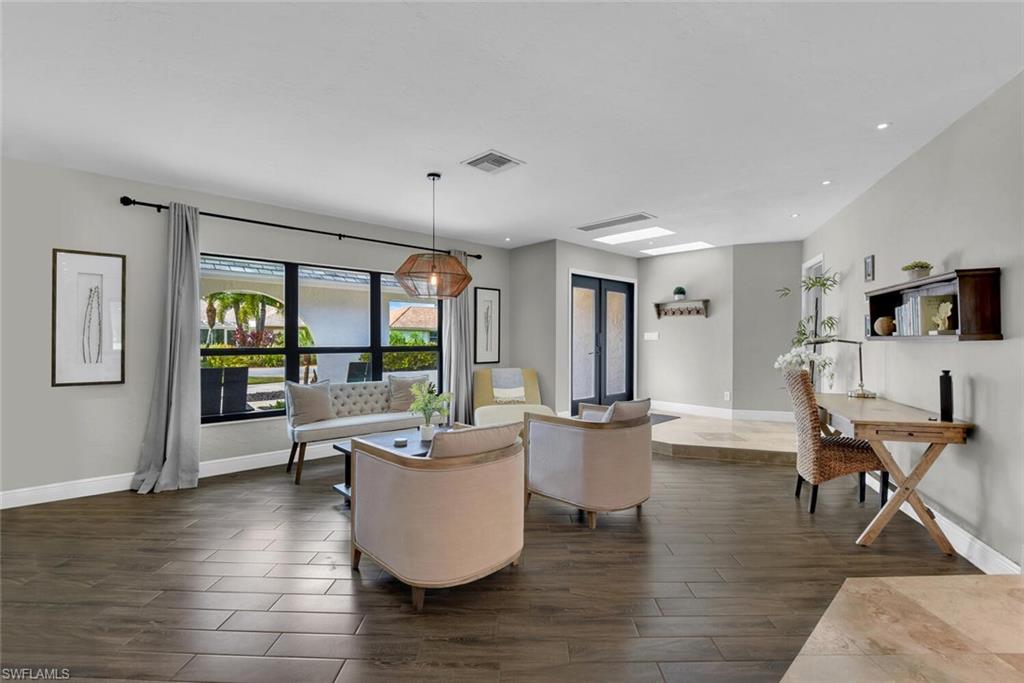167 Torrey Pines Point Naples, FL 34113 - Photo 7 of 37 a living room with furniture wooden floor and a large window