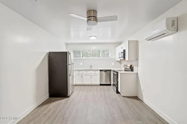 a kitchen with stainless steel appliances a refrigerator sink and white cabinets