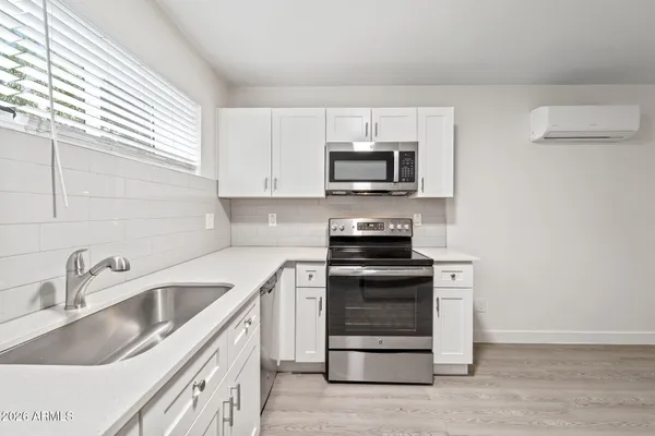 a kitchen with stainless steel appliances granite countertop a sink stove and microwave
