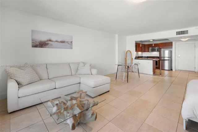 a living room with furniture and kitchen view