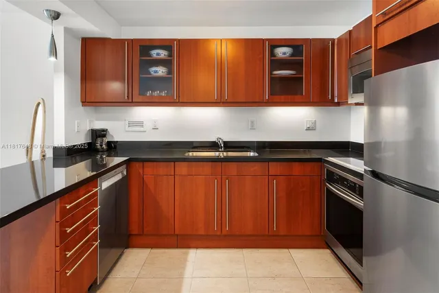 a kitchen with stainless steel appliances granite countertop a refrigerator and a sink