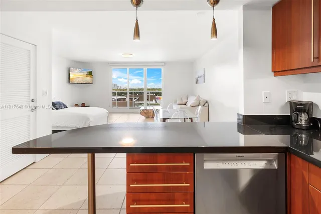 a kitchen with stainless steel appliances granite countertop a sink a stove and white cabinets