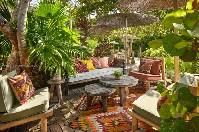 a large swimming pool with table and chairs under an umbrella