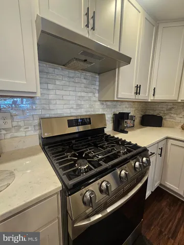 a stove top oven sitting inside of a kitchen