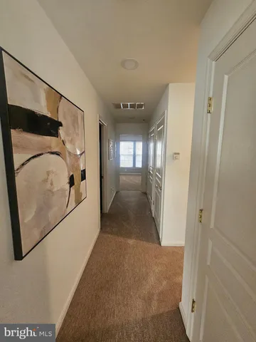 a view of a hallway with wooden floor and entryway