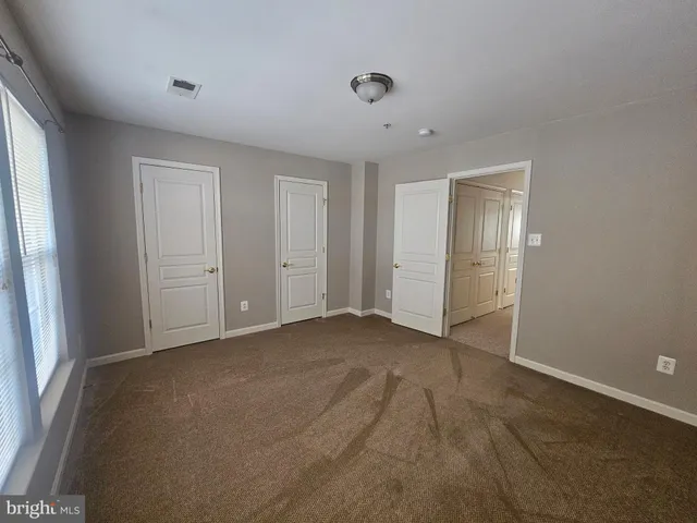 an empty room with windows and closet